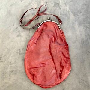 Malloni designer burgundy leather oblong purse. Clip top. Adjustable strap.